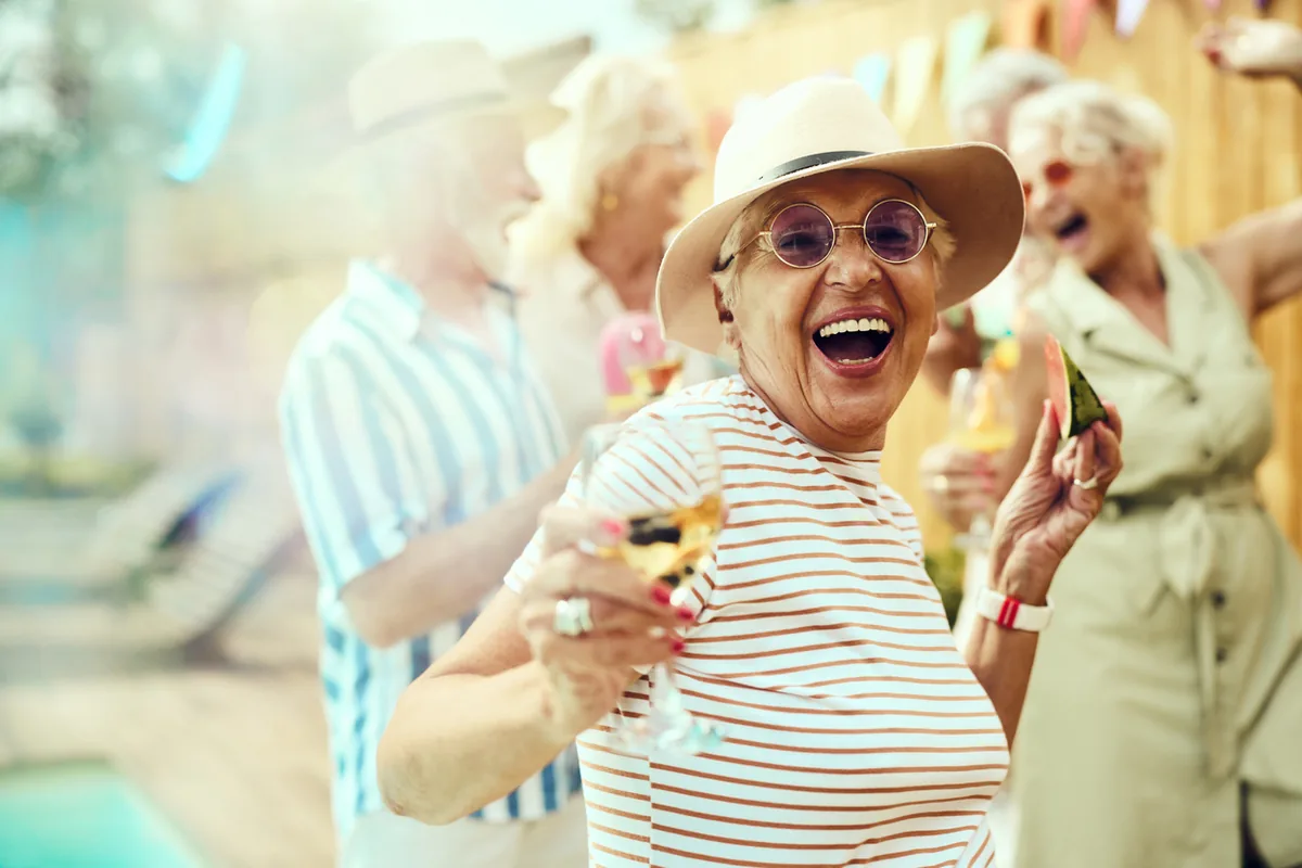 Aeltere Frauen lachen ausgelassen bei Sommerparty