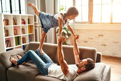 Vater spielt mit Tochter auf dem Sofa